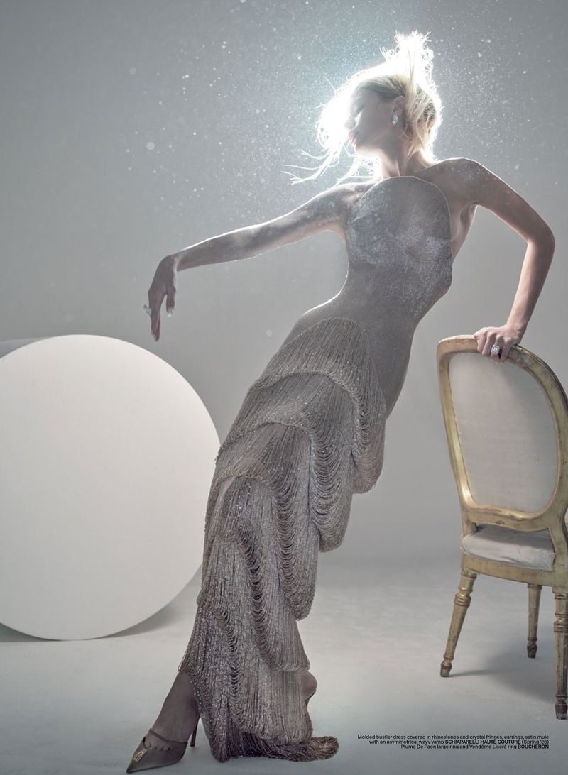 Model Maria Klaumann in a metallic fringe gown leaning against a vintage chair under backlighting for V Magazine Enlighten