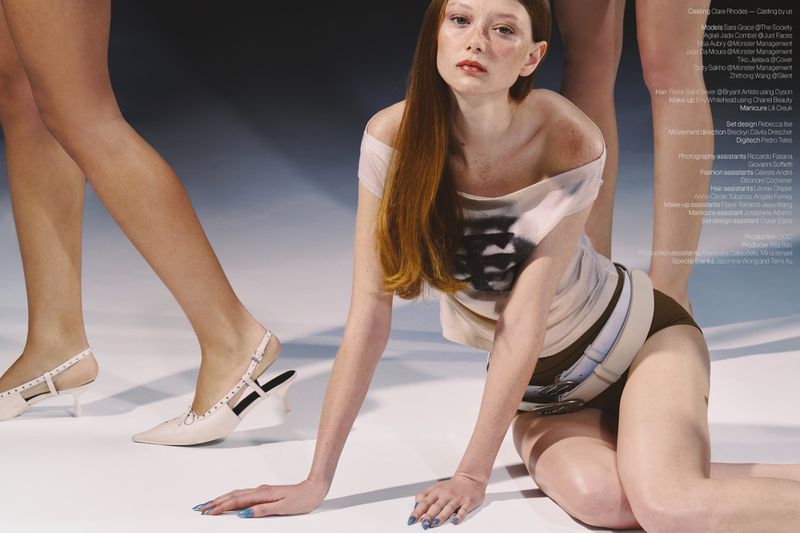 Model Sara Grace Wallerstedt kneeling in an off-the-shoulder top and belt on a studio floor for Novembre Magazine.