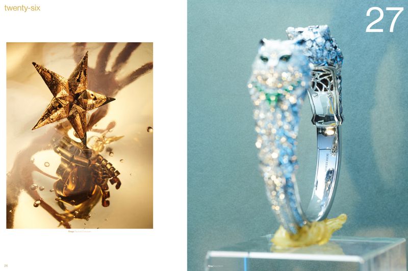 Luxury high jewelry spread featuring a diamond animal bracelet on a pedestal and a faceted gold star on a reflective surface.