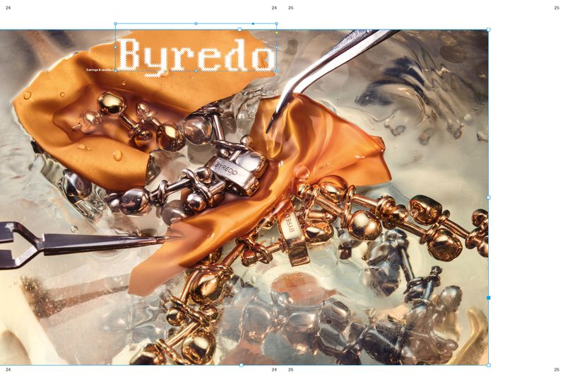 Close-up still life of Byredo gold and silver jewellery submerged in water with an amber fabric swatch and metal tweezers.