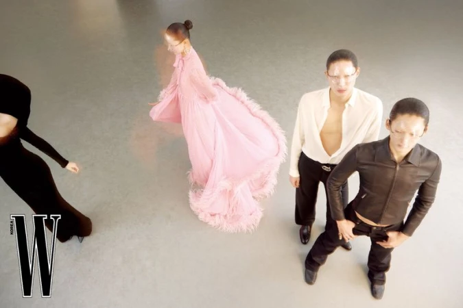 High angle shot of four models in fashionable attire on a grey seamless studio background for W Korea editorial.