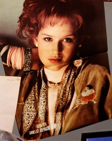 Magazine tear sheet featuring a 1980s portrait of Molly Ringwald with red hair, stacked bracelets, and patterned scarf.