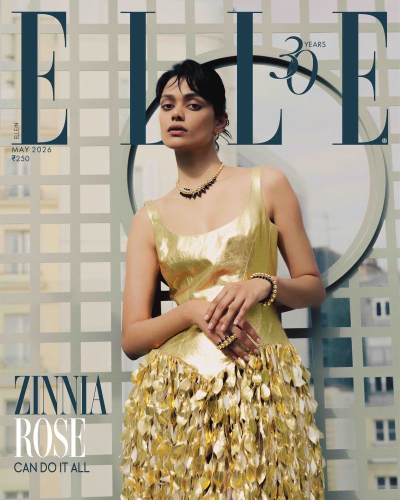 Elle Magazine cover featuring model Zinnia Rose wearing a gold dress with leaf details, posing indoors with city background. Fashion editorial.