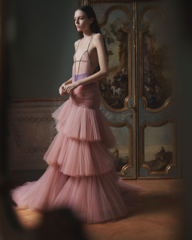 Model Saar Mansvelt Beck wearing a tiered pink tulle gown in an ornate interior with painted double doors.