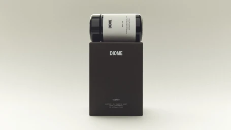 Diome Rested supplement bottle resting horizontally on its dark brown rectangular product box against a pale neutral background.