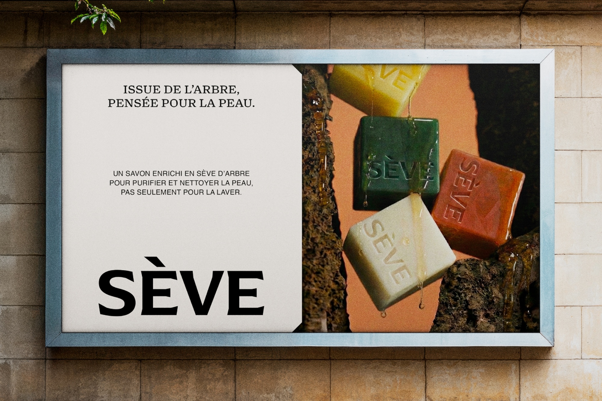 Horizontal billboard mockup on a stone wall displaying a skincare advertisement for Sève featuring colorful embossed soap bars.