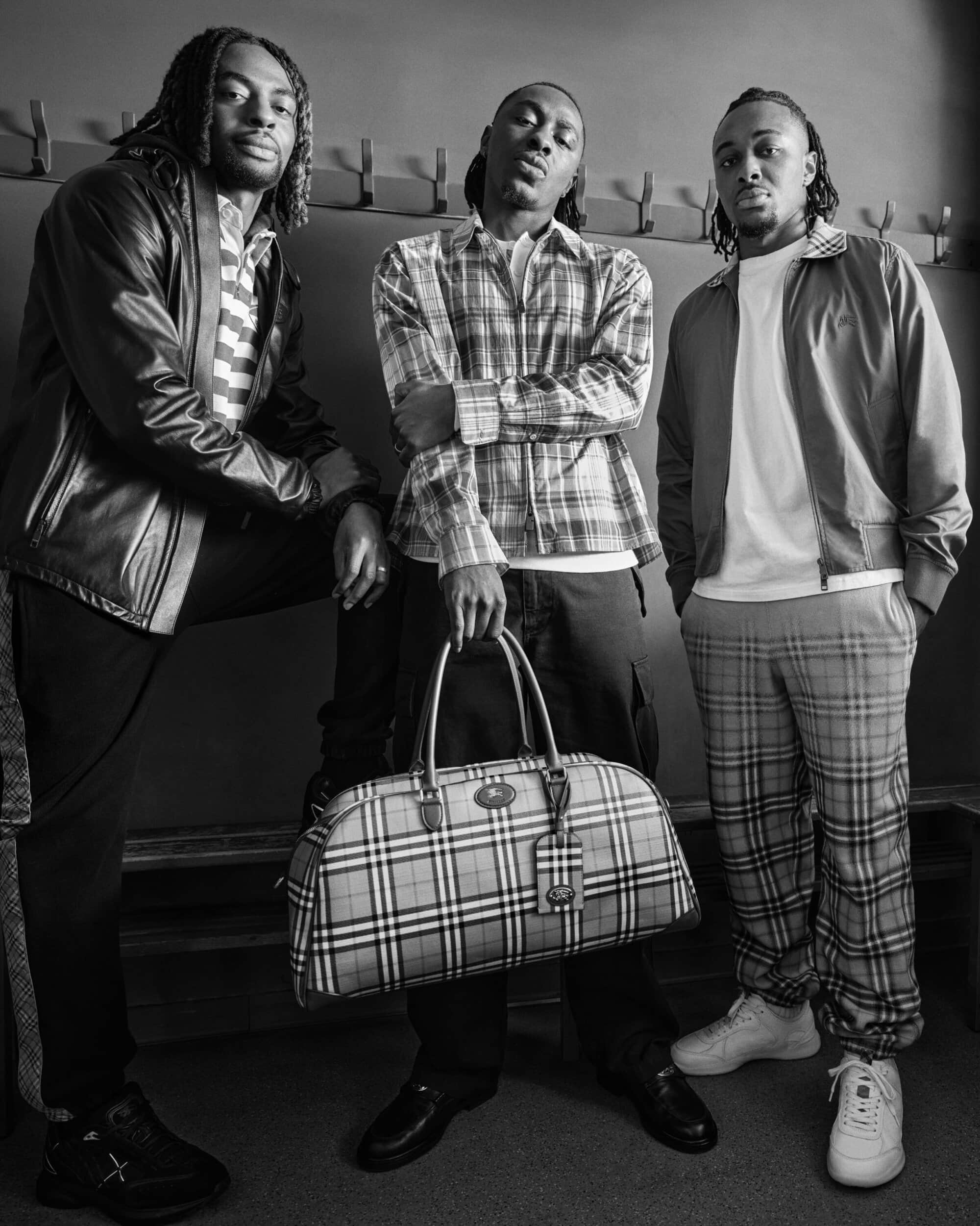 Three men posing together in a locker room setting, holding a plaid duffle bag for Burberry Fall 2026 Ad Campaign