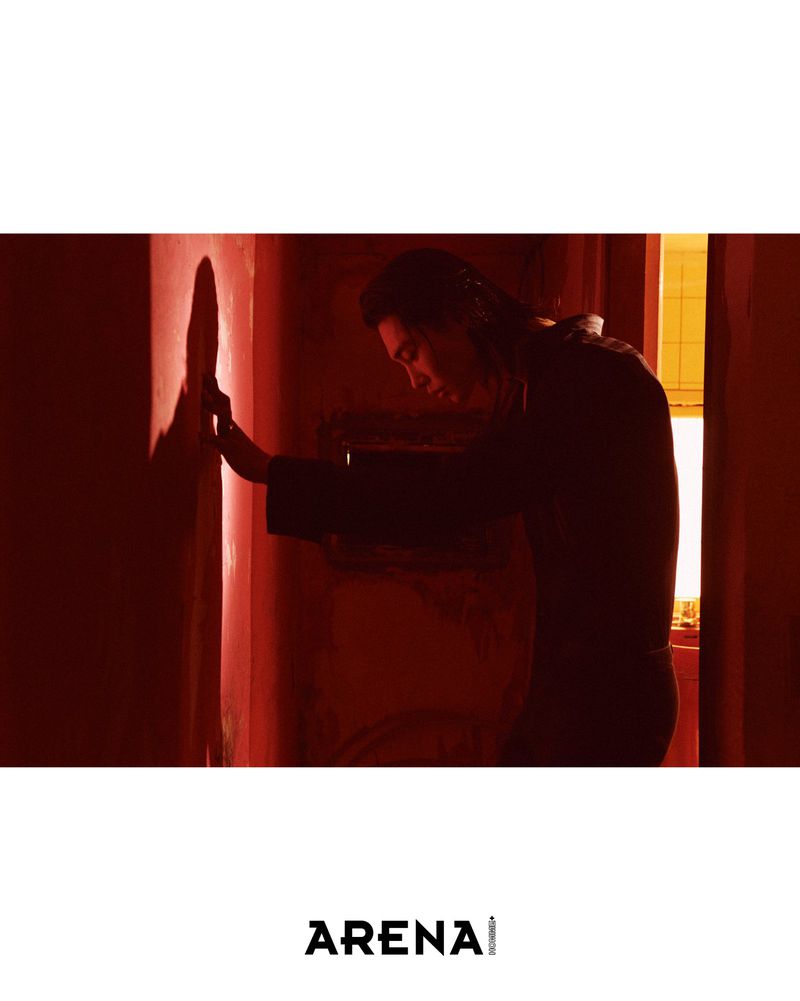 Model Taemin Park leaning against a wall in deep red lighting for Arena Homme+ Korea.