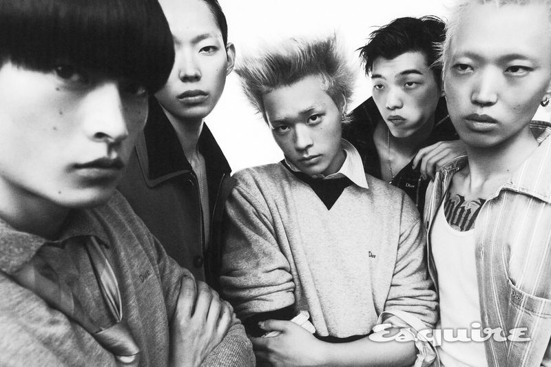 Five East Asian male models with distinct hairstyles gathered close together in a black and white fashion portrait.