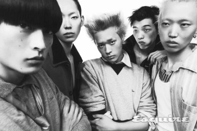 Five East Asian male models with distinct hairstyles gathered close together in a black and white fashion portrait.