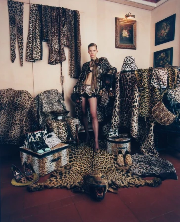Model Ida Heiner posing in an interior surrounded by leopard print clothing, fabrics, and accessories for M Le magazine du Monde.