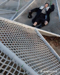 Model Minki Kwon lying on a geometric white rope net wearing a black coat with a fur collar for Esquire Korea.