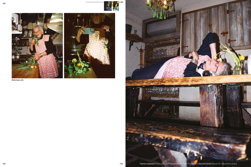 Magazine editorial spread showing artist Michel Auder wearing a pink patterned apron while lying across a rustic wooden table.