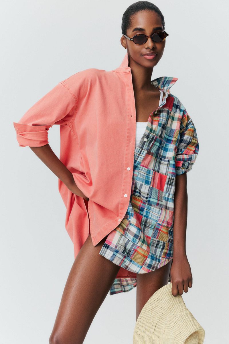 Model Tami Williams in a split coral and plaid oversized button-down shirt wearing sunglasses against a white studio background.