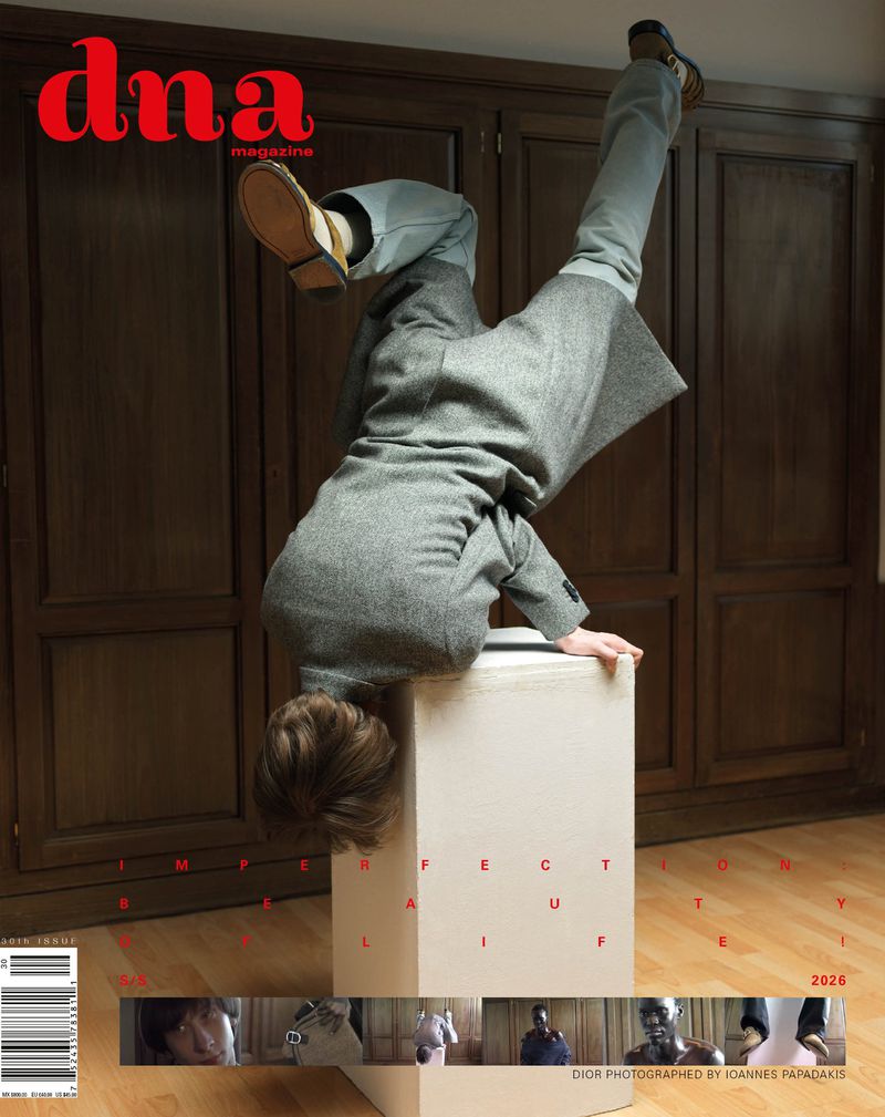 Magazine cover featuring a person in a grey coat and light pants doing a handstand on a box, with the magazine's title 'dna magazine' at the top.