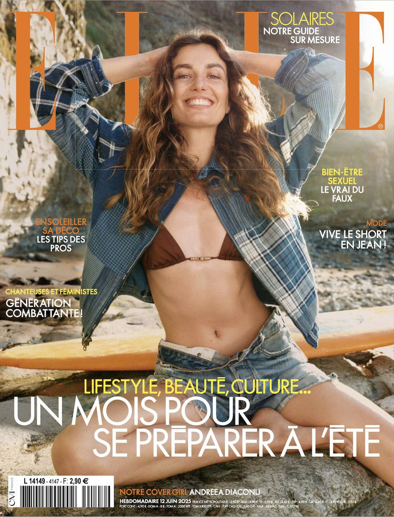 Magazine cover featuring a smiling woman in a bikini top and shorts sitting on a beach with a surfboard and wearing an open shirt.