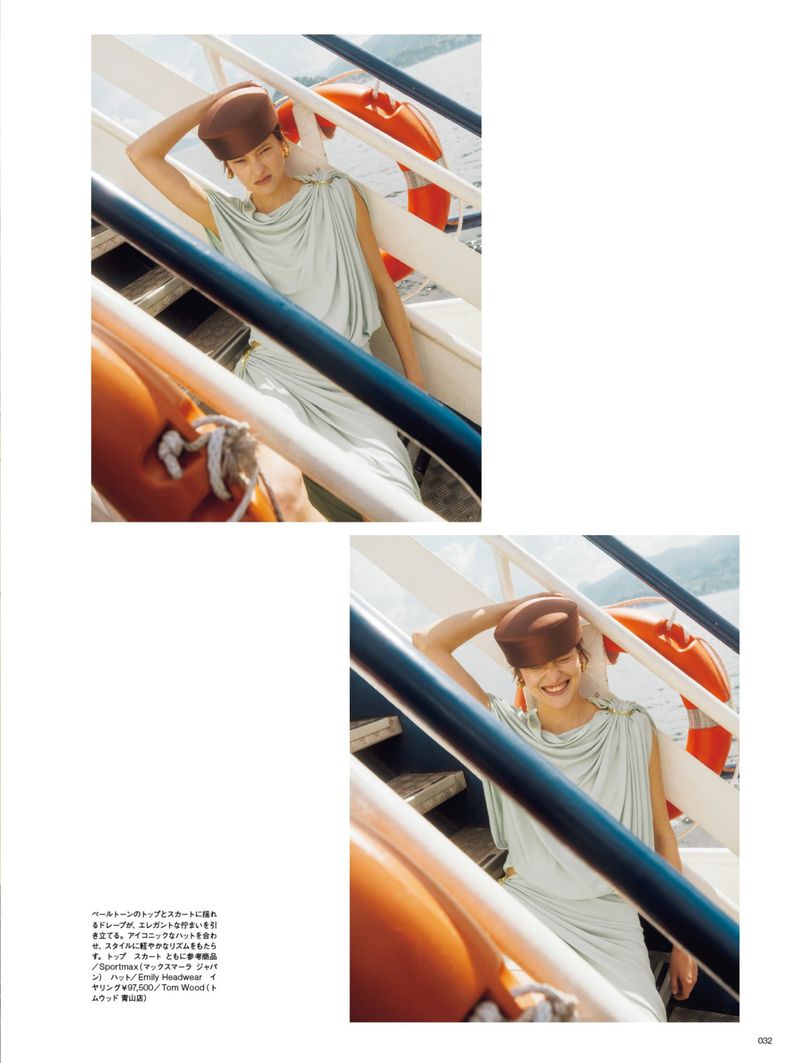 Model in light green dress and brown pillbox hat posing on a ferry stairwell for Numero Tokyo