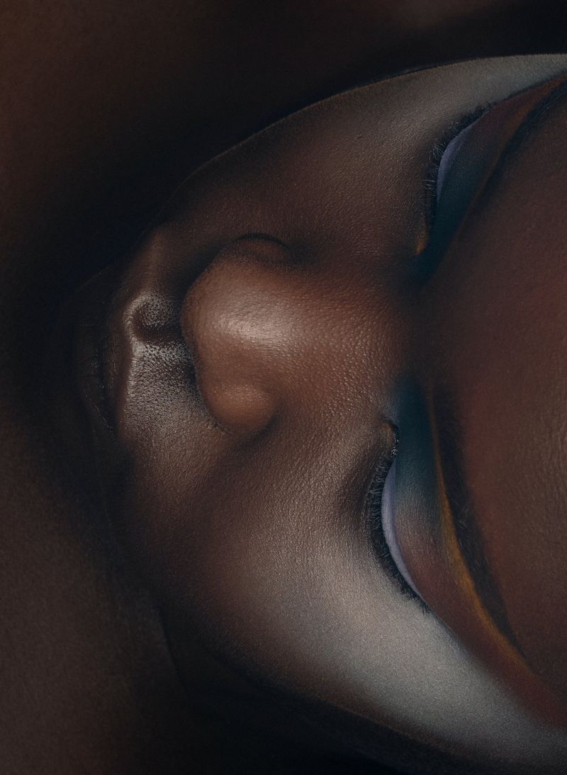 Extreme close-up beauty portrait of Ajok Daing featuring dramatic eye makeup with soft blue and white hues.