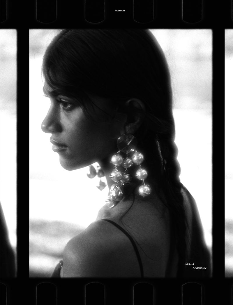 Black and white profile portrait of model Ashley Radjarame wearing large statement pearl cluster earrings framed in a 35mm film strip.