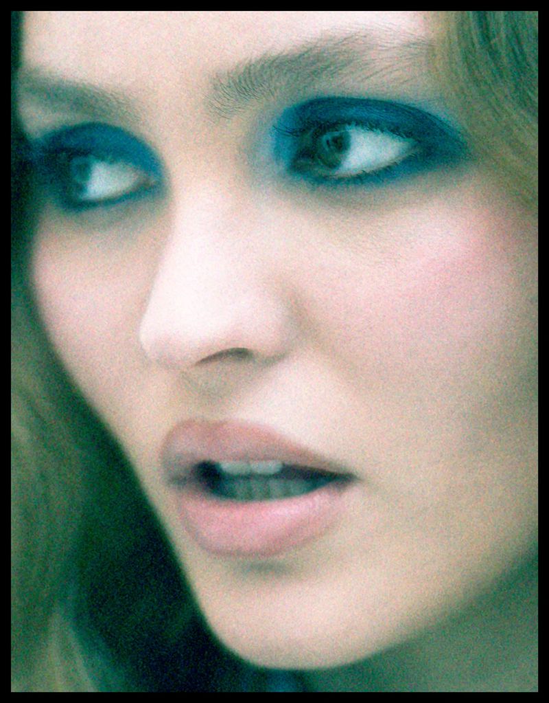 Close-up beauty portrait of Lily-Rose Depp with dramatic vibrant blue eyeshadow looking slightly off-camera.