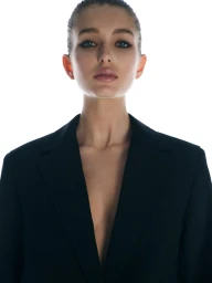 Portrait of a woman wearing a dark blazer against a bright white background