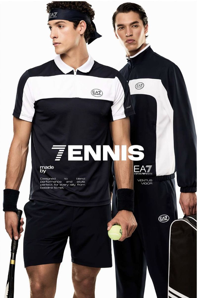 Two adult male models in black and white tennis outfits, one holding a tennis ball and racket against a bright white background.