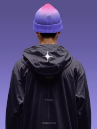 Rear view of a model in a dark hooded jacket with white star graphic and a pink to violet gradient beanie against a purple backdrop.