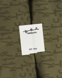 A white rectangular Kwangjuyo brand sticker sealing olive green wrapping paper printed with a Hangul typography pattern.