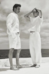 Two male models in white summer apparel standing barefoot by the ocean for Massimo Dutti