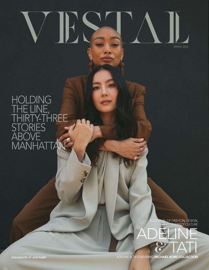 Vestal Magazine cover featuring Adeline and Tati embracing in tailored beige and brown suits against a black studio backdrop.