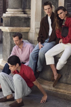 Group of four models posing on stone steps outdoors wearing casual spring apparel by Massimo Dutti photographed by Bruno Staub