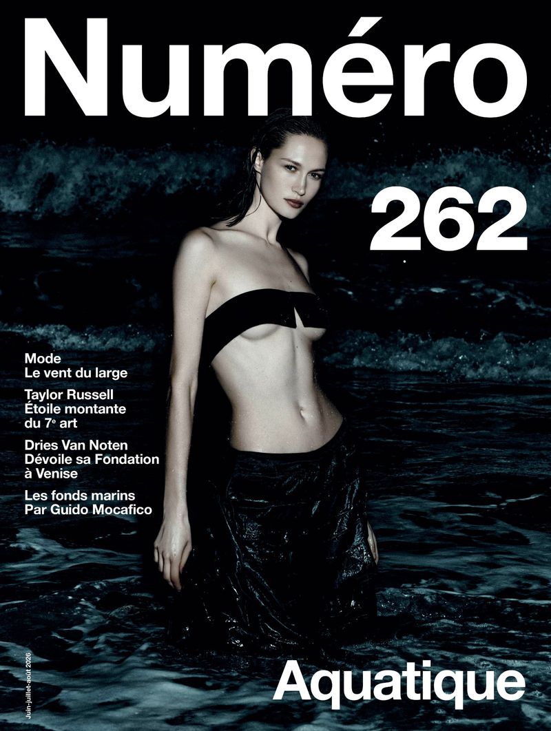 Model standing in dark ocean water at night wearing a black top and skirt for Numéro France magazine cover