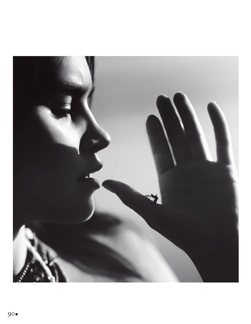 Black and white profile portrait of Olivia Aarnio raising her hand toward her lips under dramatic directional light.