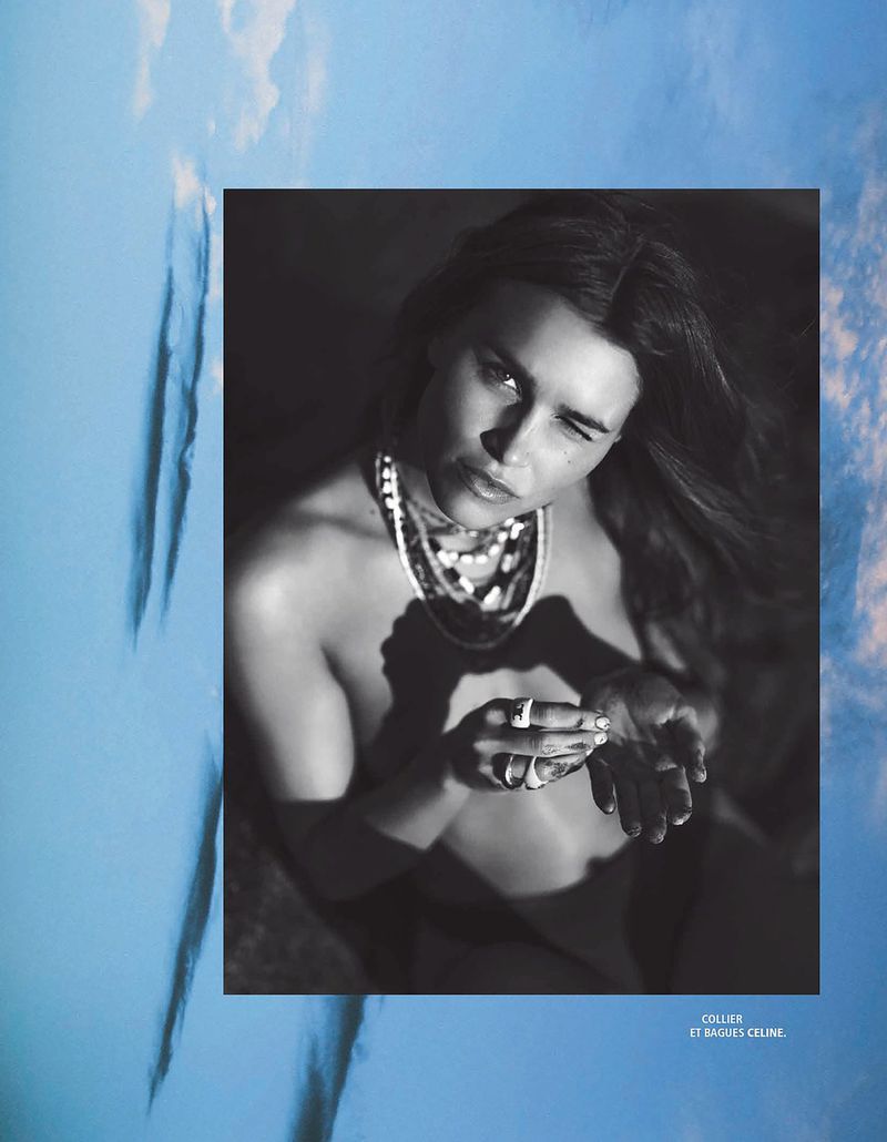 Black and white editorial portrait of model Olivia Aarnio wearing layered necklaces and rings, framed against a blue sky layout.