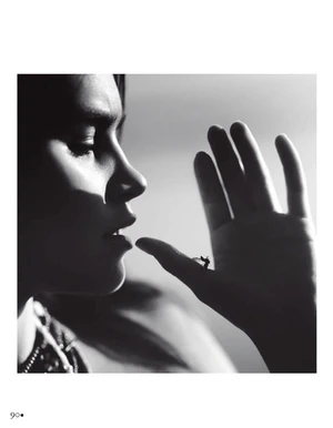 Black and white profile portrait of Olivia Aarnio raising her hand toward her lips under dramatic directional light.