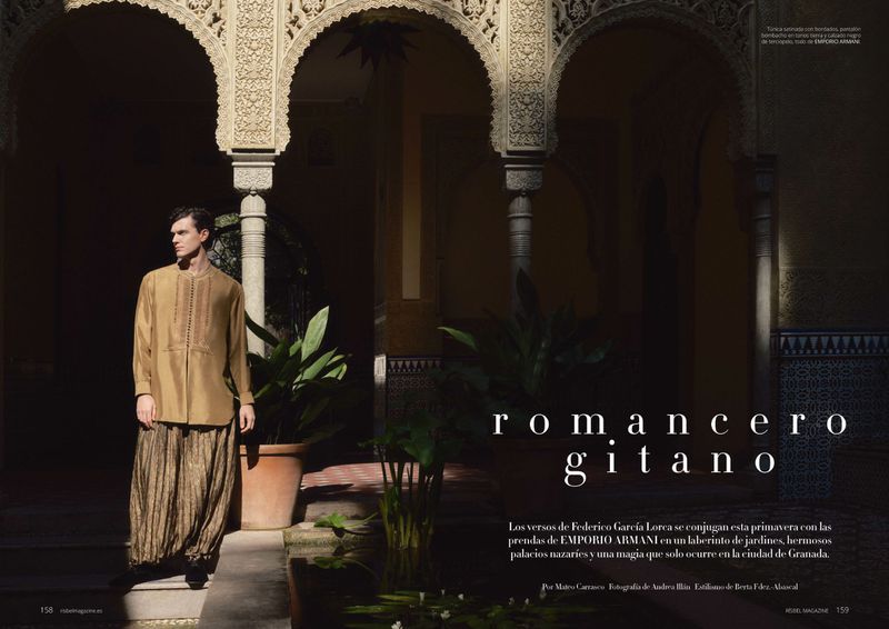 Model Xavier Serrano poses in a gold tunic and wide pleated trousers under ornate Moorish arches.