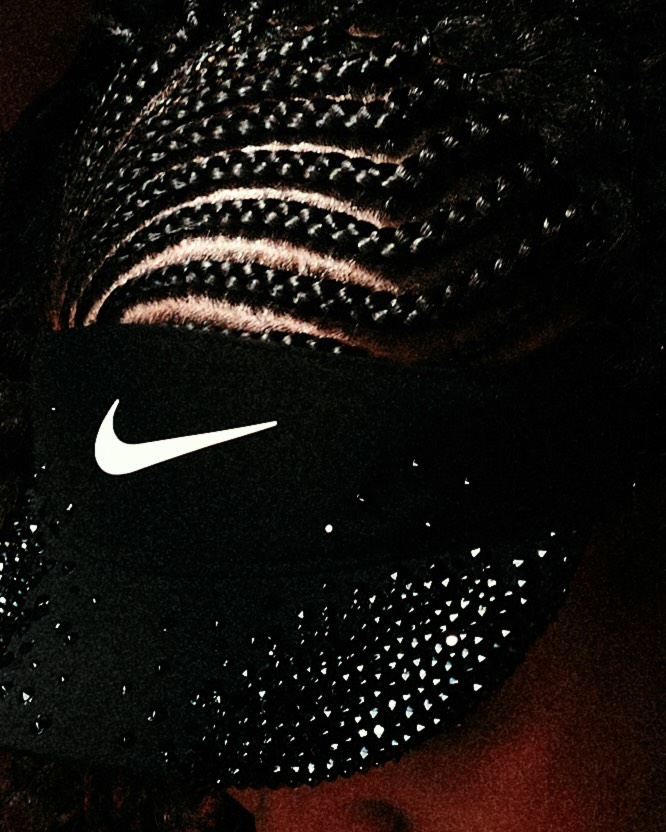 Close-up of intricate braided hair and a black Nike visor embellished with rhinestones on tennis star Naomi Osaka.