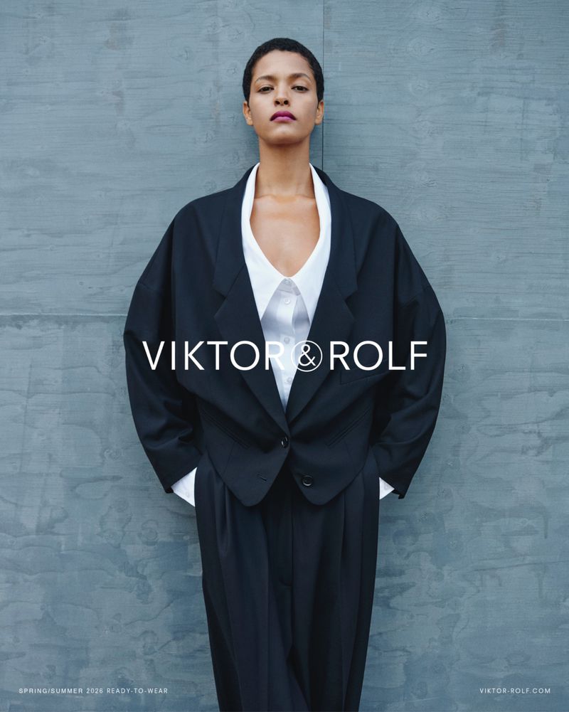 Model Laiza de Moura in an oversized black tailored jacket and white shirt against a textured grey wall for Viktor & Rolf.
