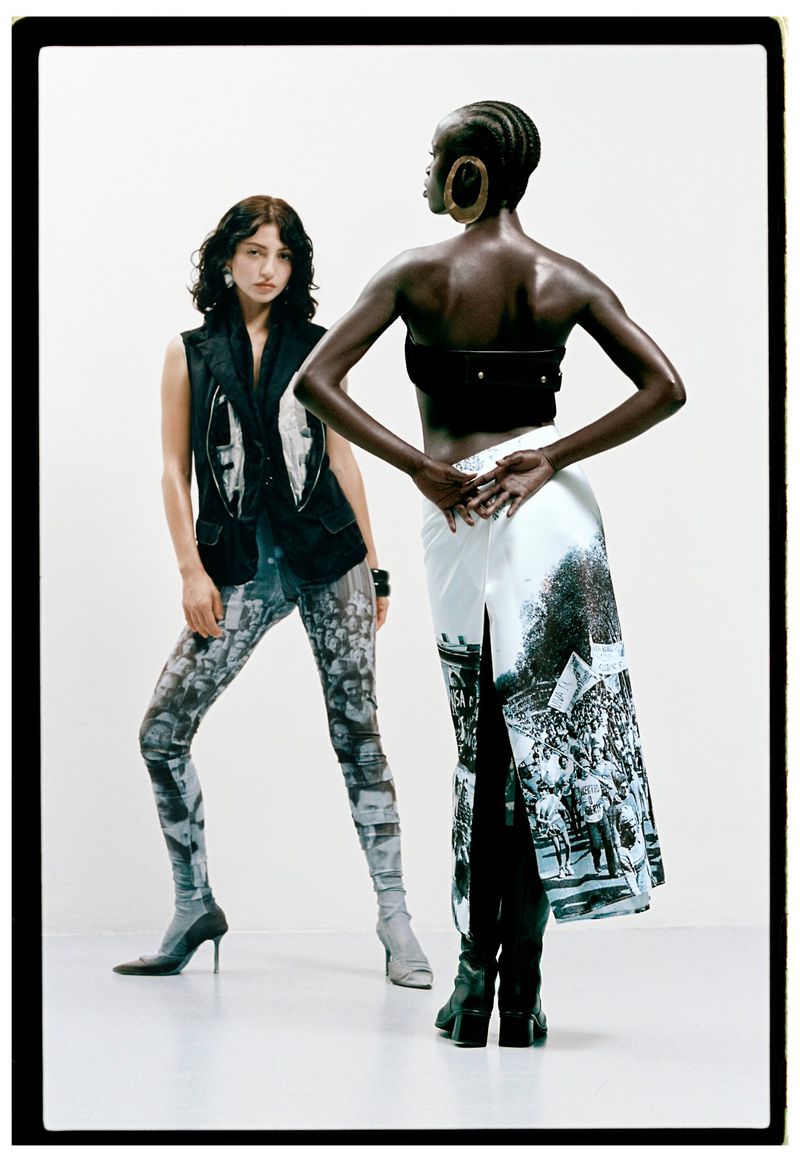 Two fashion models posing in monochrome graphic printed clothing against a bright white seamless studio backdrop.