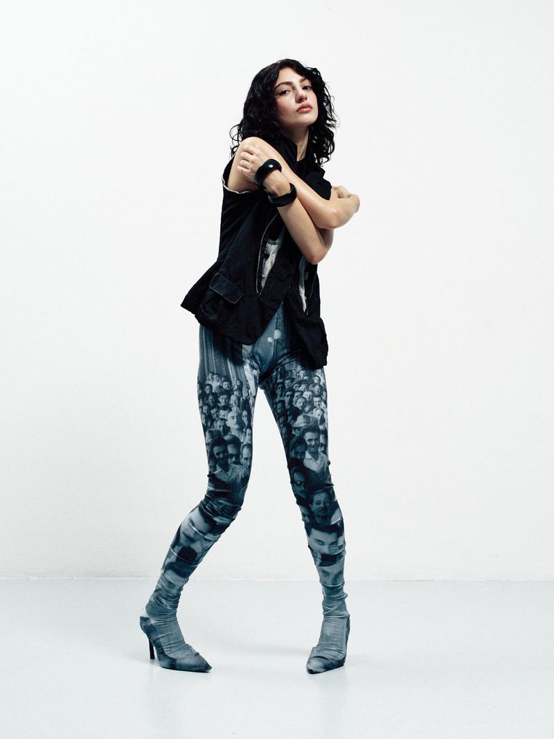 Model Grace Ayup poses in a black vest and photographic print leggings against a white studio background for Schön Magazine.