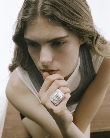 Model Anna Robinson resting her hand near her chin while showcasing a large diamond statement ring.