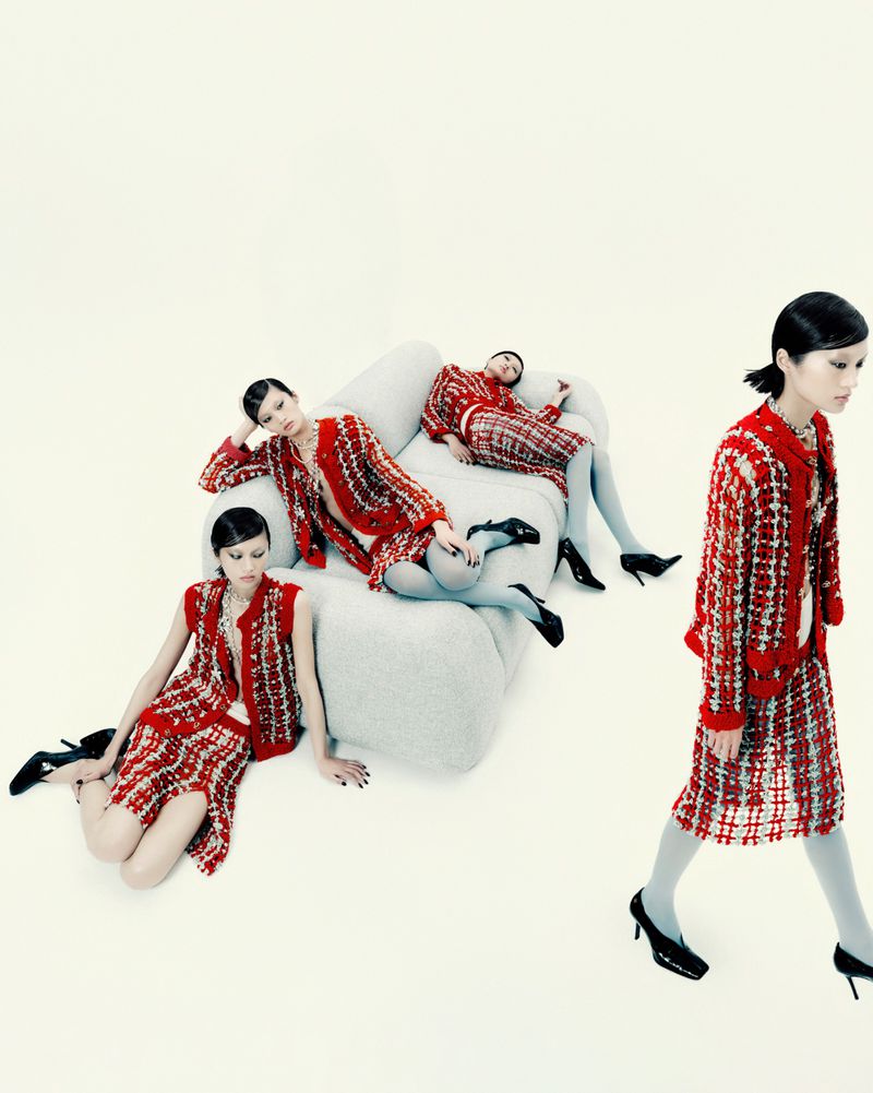 Model Yilan Hua composited in multiple poses wearing a red tweed ensemble with pale blue tights around a white sofa in a studio setting.