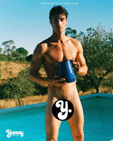Romain Beziau standing poolside outdoors holding a blue ceramic pitcher under direct sunlight.