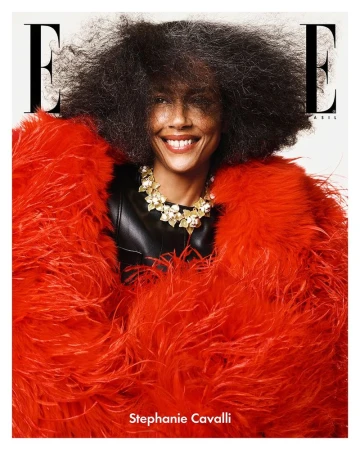 Stephanie Cavalli wearing an oversized red feather coat and gold floral necklace for an Elle Brasil magazine cover portrait.
