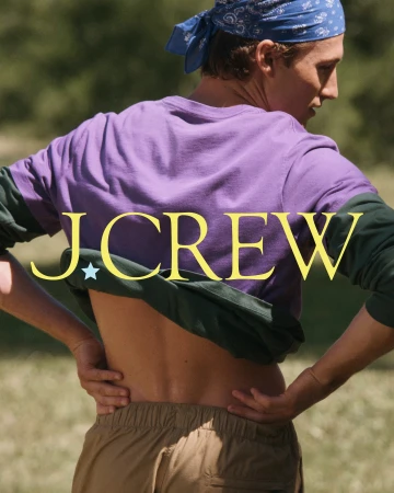 Rear view of a model in a purple shirt, blue bandana, and khaki shorts outdoors for J. Crew Camp Crew campaign.