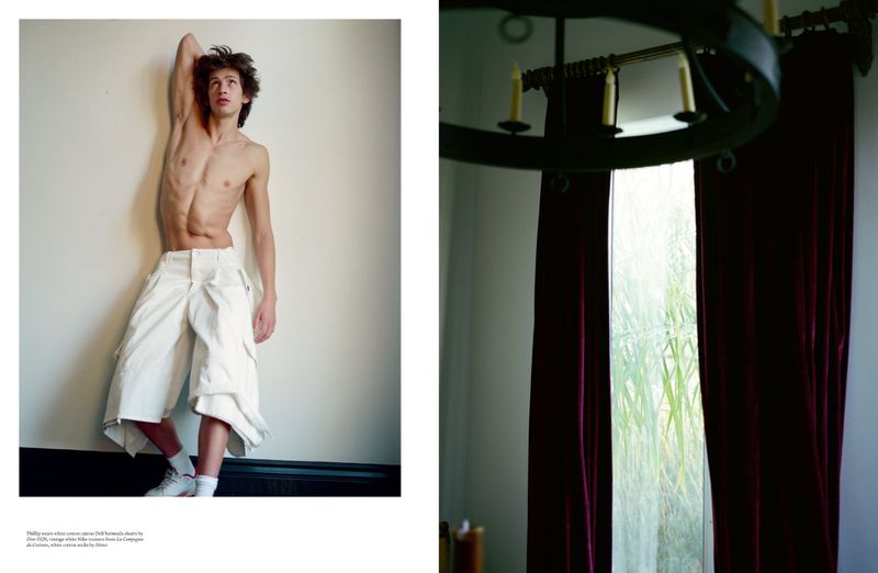 Editorial spread with a shirtless man in baggy white shorts on the left and a window framed by dark red curtains on the right.