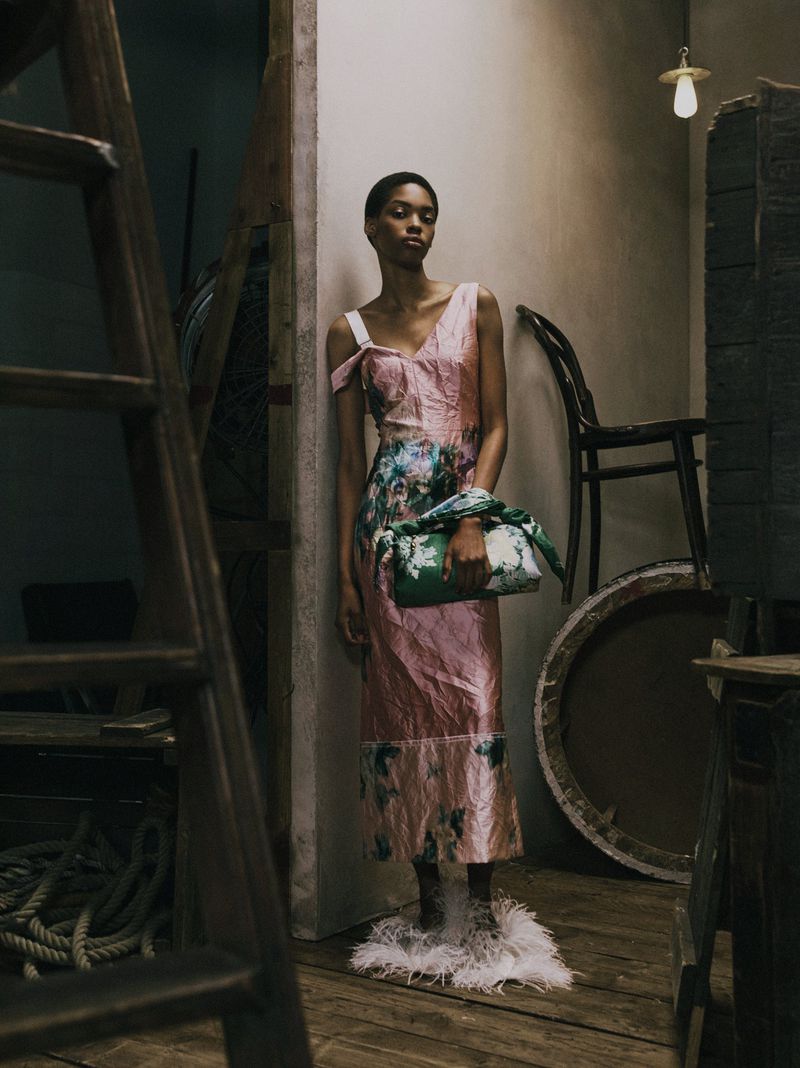 Aluel Keror in a pink floral crinkle dress and feather slippers posing for Erdem Pre-Fall 2027 Lookbook.