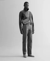 Model Nyakong Chan wearing a leather jacket, matching trousers, and a crossbody bag in a monochrome Hermès studio shoot.