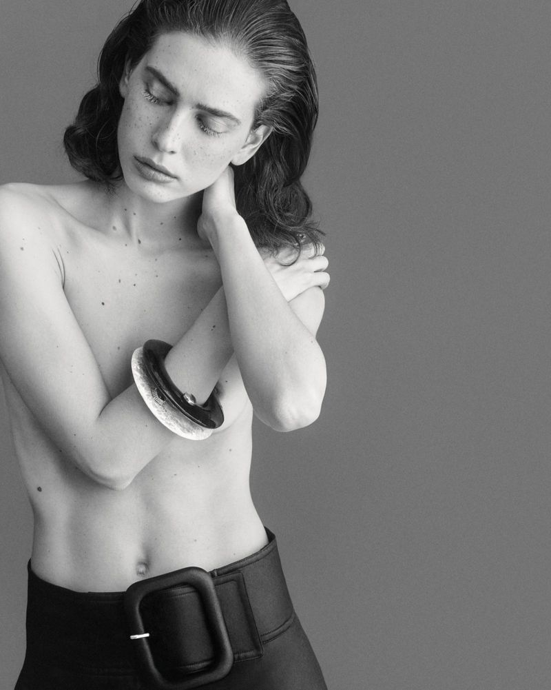 Model Sean Levy posing with crossed arms wearing a large dark belt for Duel Magazine Double Jeux
