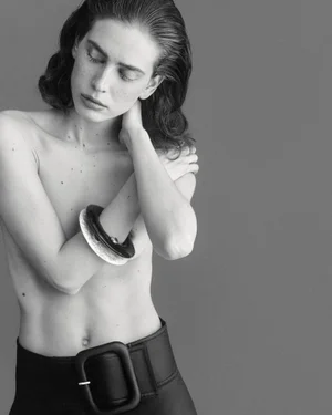 Model Sean Levy posing with crossed arms wearing a large dark belt for Duel Magazine Double Jeux